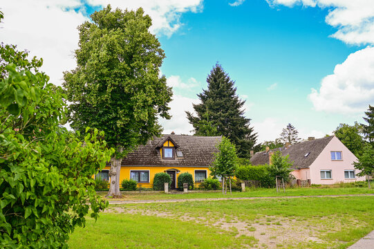 Zwei sch&ouml;ne Einfamilienh&auml;user mit Garten und B&auml;umen bei blauem Himmel im Sommer in Ketz&uuml;r, Beetzseeheide in Brandenburg, Deutschland