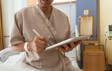 Close up, Hand of patient is signing a consent form on digital tablet to receive treatment or use...