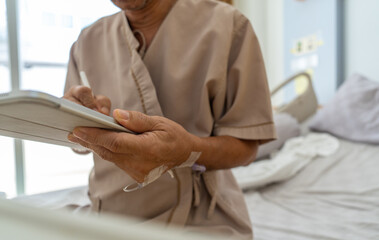 Fototapeta premium Close up, Hand of patient is signing a consent form on digital tablet to receive treatment or use health insurance rights to receive treatment in a hospital.