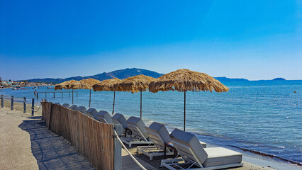 Straw Umbrellas and sunbeds on the beach in Laganas