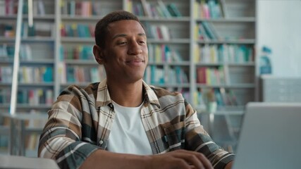 Happy African American man guy student library high school university studying learning smile typing close laptop finish work diploma done achieve learner computer e-learning online project male pupil - Powered by Adobe