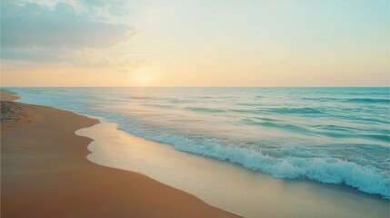 Fototapeta premium Serene beach with fine sand and soft pastel blue waves, under a gentle evening sky.