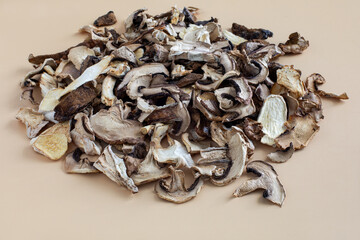 Close view of a pile of dried mushroom pieces on beige background