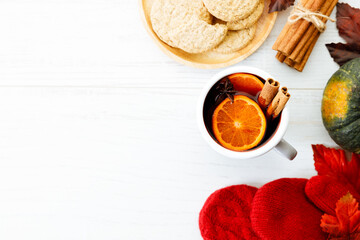 Cup of mulled wine with slices of orange and cinnamon sticks.