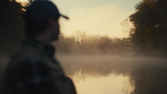 Young fly fisherman casting on a foggy river at sunrise