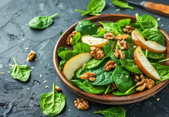 Fresh spinach and pear salad with walnuts and parmesan on a clay plate Vegan and healthy Dark background with space for text