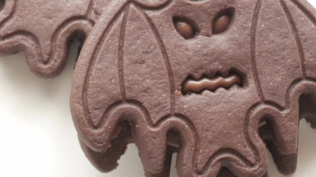 A close-up of a chocolate bat-shaped cookie with detailed features, perfect for Halloween themes