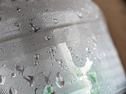 Close up of a plastic bottle filled with cold water with condensation drops. food and drink background.