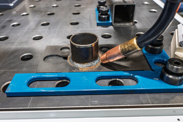 Robot welding steel. Industrial welding robot and working with metal parts. Robot welds steel. Welding head. Welding robot. CNC welding. Robotization and automation of the welding process.