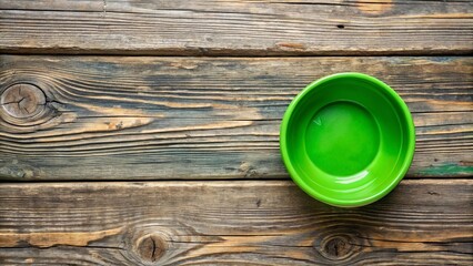 A solitary green bowl rests on a weathered wooden surface, a simple and minimalist composition.