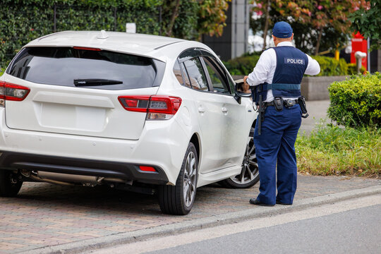 交通違反をした運転手に反則切符を発行する警察官