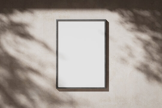 Blank white portrait A0 poster in a metal frame on a plaster wall
