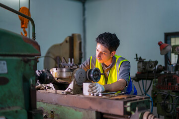 Blue collar worker upskills at lathe machine shop.