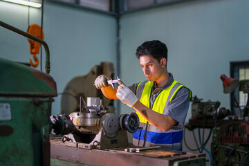 Blue collar worker upskills at lathe machine shop.