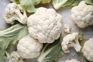 Fresh cauliflower and leafy greens arranged beautifully in an overhead shot taken indoors