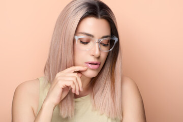 Stylish woman wearing clear eyeglasses with a neutral background