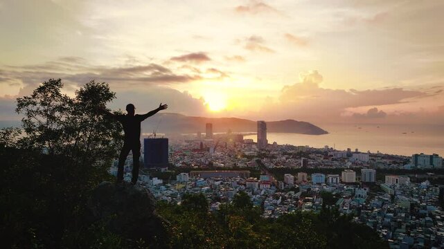 Quy Nhon, Vietnam - Silhouette of a person embracing cityscape at sunset