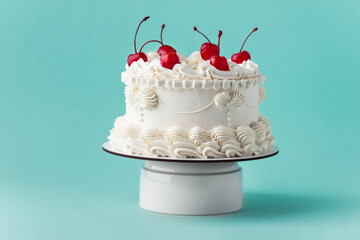 Delicate lambeth style birthday cake with white cream cheese frosting decorated with cocktail...