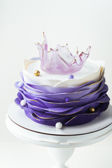 Beautiful cake with violet mastic frosting decorated with caramel transparent vase on top....