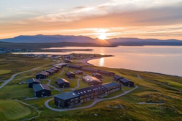 Obraz premium Scenic Sunset Over Coastal Village with Modern Architecture in Nature's Embrace