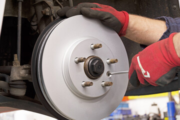 Nahaufnahme vom Einbau einer neuen Bremsscheibe eines modernen PKW