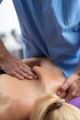 Fototapeta premium Physical therapist performs a deep tissue massage on a patients shoulder to relieve muscle tension and improve mobility in a therapeutic setting