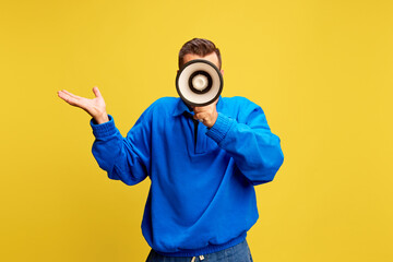 Man dressed casual outfit holds megaphone and gestures questioningly, appearing to ask for feedback...