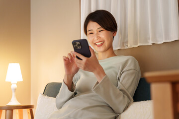 夜スマホを見る女性