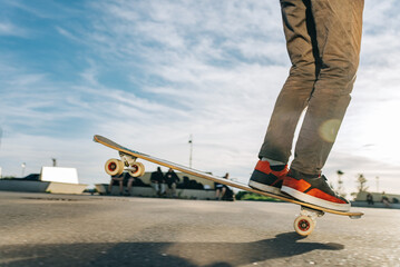 Skateboarder skillfully balances on one wheel at a busy skatepark. Showcasing his athletic prowess...