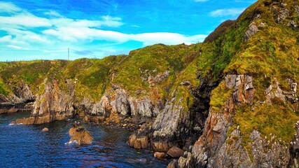 Fototapeta premium Enjoy the breathtaking view of a stunning coastal landscape with rocky cliffs and serene waters