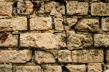 Weathered stone wall with rustic textures and rich patterns in natural hues during daylight hours