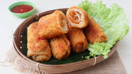vegetables risoles or risol sayur or risoles sayur stuffed with veggies and enclosed in crepe-like wrappers and rolled into bread crumbs and fried. served on wicker bamboo plate. selected focus