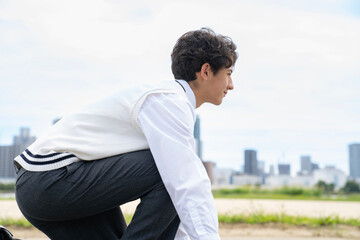 クラウチングスタートの構えで座る男子学生