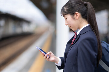 スマホを見る女子高生