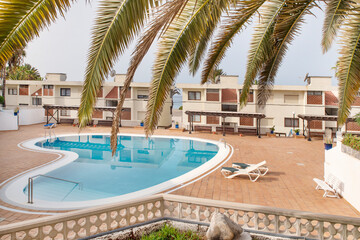 Relaxing view of the residential complex with a large swimming pool with sunbeds, spacious grounds and apartment blocks at Vera Mar Beachfront Complex, Tenerife, Canary Islands, Spain