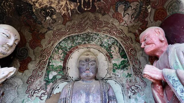 Maijishan, China: Tilt down footage of ancient Buddhist statues in the famous Maijishan grottoes complex near Tianshui in China which date back to 4th century. 