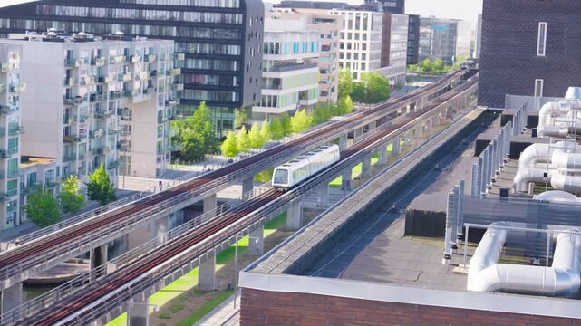 Futuristic Copenhagen city landscape with train on Orestad metro line