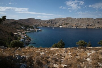 Fototapeta premium Scenic coastal bay with rocky hills and village.