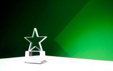Sustainability award - star-shaped crystal prize on a table with green spotlights and copy space