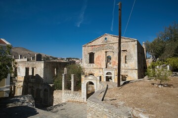Abandoned stone building in rural landscape.