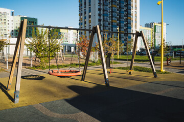 Vibrant and Colorful Playground Swings Nestled Amidst Contemporary Residential Structures, Perfect for Fun and Enjoyment in the Neighborhood