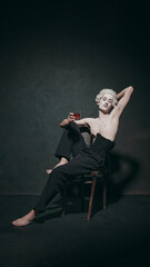 Man posing dramatically with drink, with playful take on aristocratic decadence, merging history...