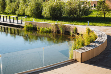 Fototapeta premium Experience the tranquil beauty of Serene Waterfront Park, featuring curved benches nestled among lush greenery, inviting exploration and relaxation