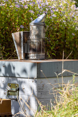 Apiculture - enfumoir pos&eacute; sur une ruche pendant une visite sanitaire d'un rucher par l'apiculteur.