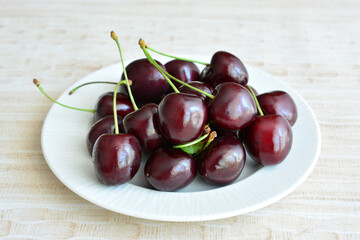 a white plate with a handful of cherries on it macro