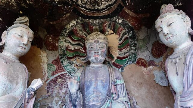Maijishan, China: Tilt down footage of ancient Buddhsit statue in the famous Maijishan grottoes complex near Tianshui in China which date back to 4th century. 