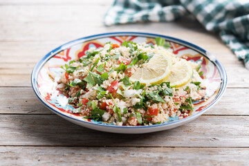 Tabbouleh salad with couscous on wooden table