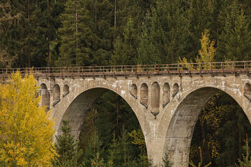 Fototapeta premium Klassische Seitenansicht der massiven Bogenstruktur am Finsterer Grund Viadukt, historische Eisenbahnbrücke im herbstlichen Thüringer Wald bei Neuhaus am Rennweg, Landkreis Sonneberg, Deutschland