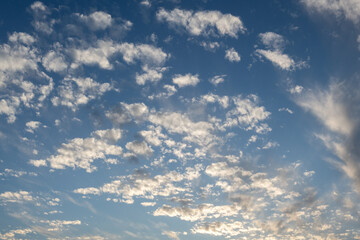 Cirrostratus or cirrus cloud formations against a blue sky in afternoon sunlight.