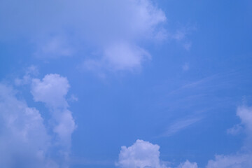 Bright blue sky with fluffy white clouds on a sunny day